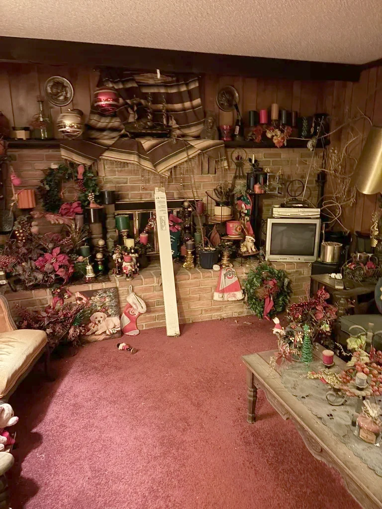Lower level as purchased, brick fireplace wall behind stacked belongings